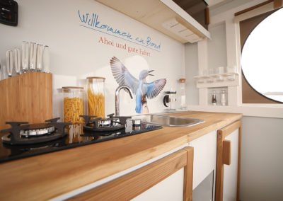 Küchenecke mit Herd und Spüle im Eisvogel Maxi Hausboot